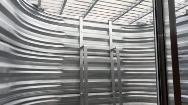 Pencerenin içinden koruyucu çelik ızgarasını ve merdivenini göster. İnşaat veya güvenlik talimatları için kullanışlı.