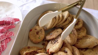 Ev yapımı kurabiyelere, çikolata parçalarına ve yumuşak dokulara yakından bakmak. Kurabiyeler servis için beyaz tepsiye konur..