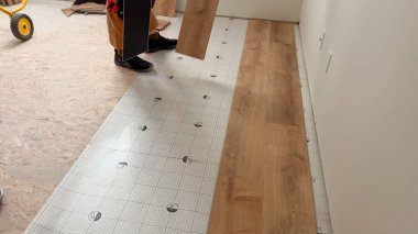 Parker, Colorado, ABD-7 Temmuz 2024 - Görünür alt katlı ve vinil döşemeli bir koridorda kısmen tamamlanmış bir döşeme işi. Aletler ve inşaat malzemeleri etrafa saçılmış.