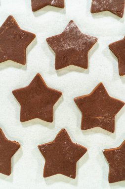 Parşömen kağıdına yerleştirilmiş çiğ çikolatalı kurabiyelerin yakın plan görüntüsü, temiz kenarlarını vurguluyor..