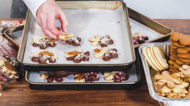Dikkatlice paketlenmiş Noel kurabiyeleri, çikolataya batırılmış ve şeffaf selofan ambalajla sunulmuş, bayram hediyesi olarak mükemmel..