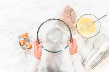 Düz yatıyordu. El çırpma makinesiyle, malzemeler cam karıştırma kabında ustalıkla karıştırılarak nefis bir çikolatalı kek elde ediliyor..