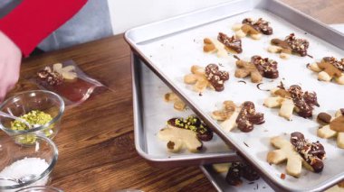 Dikkatlice paketlenmiş Noel kurabiyeleri, çikolataya batırılmış ve şeffaf selofan ambalajla sunulmuş, bayram hediyesi olarak mükemmel..