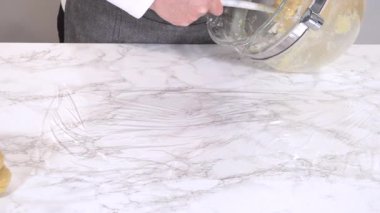 Soluk bir kurabiye hamuru yığını mermer bir tezgahın üzerine plastik ambalaja konur. Hamur paketlenip soğutulmaya hazır..