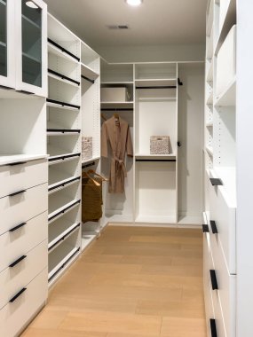 Dolapta beyaz dolaplarla modern bir yürüyüş. Çekmeceler ve askılar da dahil. Organize tasarım, giysi ve aksesuarlar için işlevsel ve şık bir depolama çözümü yaratır.