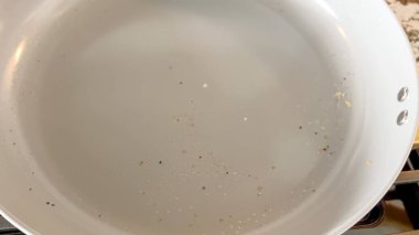 Arka planda karla kaplı ağaçların ve banliyö evlerinin yakınında yürüyen bir geyiğin olduğu karlı bir arka bahçe sahnesi. Mevsimsel ya da vahşi yaşam temaları için mükemmel.