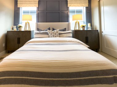 Castle Pines, CO, ABD-6 Ekim 2025 - Çizgili yatak odası, iki komodin ve geniş pencereli, gün ışığının boşluğu doldurmasına izin veren. Oda sıcak ve temiz tonlara sahip.