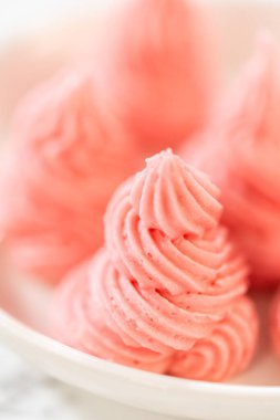 Paskalya Kurabiyesi Sandviçi 'nde ahududu kremalı ve ahududu ezmeli sandviçin dokusunu ve kıvrımlı detaylarını gösteren yakın çekim makro resmi. Eğitici veya estetik gıda içeriği için harika.