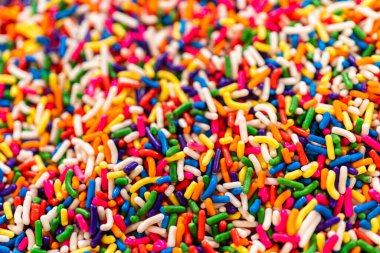 Yakın çekim makro çekim ve geniş kompozisyonlarda çekilmiş canlı bir gökkuşağı serpintisi. Serpinti serpiştirilir ya da kavanozlara yerleştirilir koyu sarı bir arkaplan üzerine, neşeli ve