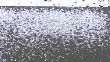 Dış yüzeyi yoğun bir şekilde kaplayan dolu taşlarını gösteren detaylı bir görüntü. Dolu taşları, dolu fırtınasının şiddetini gösteren kalın bir katman oluşturuyor..