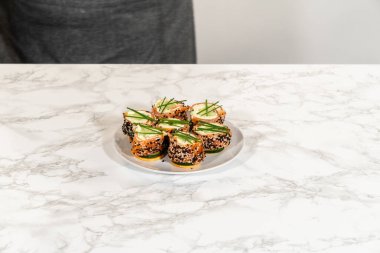 Tütsülenmiş somon peynirli peynirli ruloların daha yakın bir görüntüsü. Karmaşık tabakalarını ve taze malzemelerini vurguluyor..