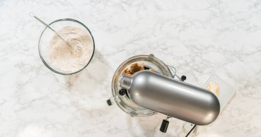 Bir stand mikserinin etrafında toplanan malzemeler, canlı zencefilli kurabiyeler için birleştirilmeye hazır. Yeşil renk karışımı ve kuru malzemeler tereyağı ve şekerin yanına konur.