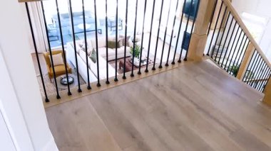 Zarif bir evin içinde, cilalanmış ahşap zeminler sofistike cam kaplamalarla süslenmiş bir koridorda yol gösteriyor. Tırabzanın sıcak ahşap tonları davetkar ve lüks olanı tamamlıyor.