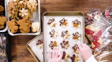 Düz yatıyordu. Dikkatlice paketlenmiş Noel kurabiyeleri, çikolataya batırılmış ve şeffaf selofan ambalajla sunulmuş, bayram hediyesi olarak mükemmel..