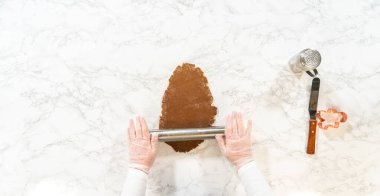 Baharatlı Zencefilli Kurabiyeler için hamur yuvarlama sürecinin genel görünümü, mermer bir yüzey üzerinde hamur rulo gösteren yakın araçlar ile araçlar.