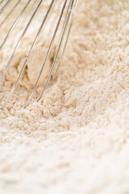 Un ve baharat karışımının yakın plan bir araya getirilmesi ve baharatların eşit bir şekilde dağıtılması. Bu, klasik kızıl zencefilli çörek hamurunun tutarlı bir lezzet profiline sahip olmasını sağlar..