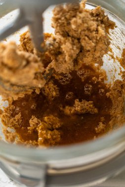 Kremalı karışıma akçaağaç pekmezi ve yumurta olarak bir stand-up 'ın yakın plan yan görüntüsü eklenerek Amber Zencefilli Kurabiye Hamuru için koyu ve zengin bir taban oluşturulur. Akçaağaç şurubu sıcak bir renk sağlar.