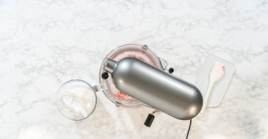 Limon spreyli kurabiyeler için yakın plan bir karıştırıcı, borular ve şekillendirme için hazır narin kurabiye şeklinde. Bir spatula kâseyi kazımak için görünür..