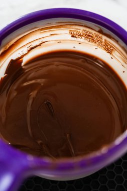 Mor bir eritme kabında pürüzsüz eritilmiş çikolata, naneli şekerli kurabiyeler için mükemmel hazırlanmış..