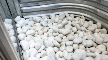 Pencere kuyusunun üst görüntüsü metal çerçeveyi kaplayan beyaz yüzey kayalarını ortaya çıkarır. Işık tonları gümüş duvarla tezat oluşturuyor..