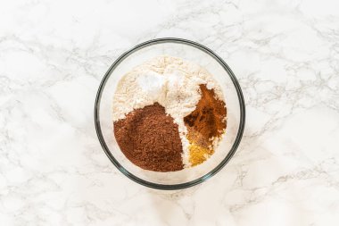 Kuru baharat ve un tabağında ince baharatlı zencefilli kurabiye için en iyi manzara. Zencefil, tarçın ve karanfil gibi baharatlar un içinde ayrı bölümlerde görülebilir.