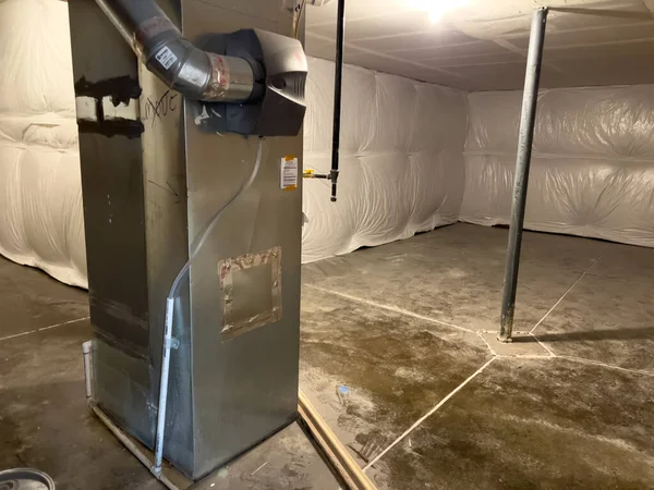 Parker, Colorado, ABD-1 Haziran 2025 - Beton döşeme ve beyaz yalıtımlı temiz bir emekleme alanı merkezi havalandırma ünitesini kanal işçiliğiyle kapatır. Mekanik sistem ısıtma ve hava için kurulur