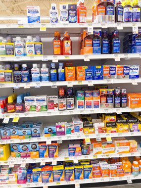Tamamen dolu bir eczane rafında, Castle Rock, Colorado 'daki NyQuil, DayQuil ve Mucinex de dahil olmak üzere çeşitli soğuk algınlığı ilaçları sergileniyor. Organize düzen editoryal kullanım için mükemmeldir veya