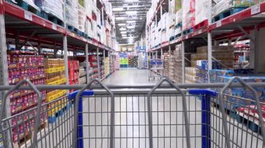 Parker, Colorado, ABD-20 Haziran 2025 Slow Motion, depo tarzı bir dükkanda renkli ambalajlarla yemek reyonunda yürüyor. Video, Sam 'deki bir alışveriş arabasından tüketici görüntüsünü çekiyor.