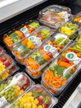 Castle Rock, CO, ABD-19 Ekim 2025 - Dondurulmuş bir markette sebze ve meyve tabağı seçimi sergilenmektedir. Organize düzen ve parlak ışıklandırma vurguluyor