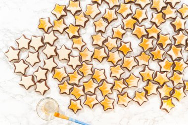 Kraliyet kreması ile süslenmiş zencefilli kurabiyelerden oluşan sanatsal tepeden tırnağa bir düzenleme, altın tozuyla süslenmiş, bu şenlikli ziyafete büyüleyici bir son katıyor..