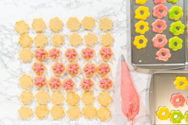 Vibrant flower cookies being layered with raspberry buttercream in this Easter Cookie Sandwich with Raspberry Buttercream recipe. Great for visual storytelling and step-by-step baking projects.