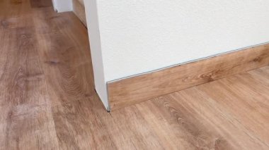 Süpürge alanı, CO, USA-227 - 16 Şubat 2025 - Yeni yapılmış ahşap döşeme kenarına sıkıca oturan tahta süpürgenin yakın çekimi. Temiz hatlar ve rahat uyum,