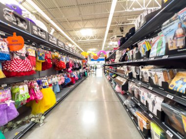 Parker, CO, ABD-19 Eylül 2025 Cadılar Bayramı kostümleri, şekerler ve dekorasyonlarla dolu uzun bir mağaza koridoru. Parlak renkli eşyalar raflardan sarkıyor ve rafları güçlü ışık altında diziyor. Şey...