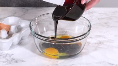 İki çiğ yumurta, üzerine koyu şurup dökülmüş cam bir kasede dinleniyor. Kase mermer bir tezgahın üzerine kurulmuş, yanında da mermiler var..