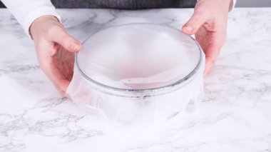 Beyaz mermer yüzeyinde şeker küpleri olan cam bir kasede tek bir taze çilek gösteren yakın çekim video klibi. Parlak ışıklandırma, temiz dokuları ve minimalist gıda tasarımını ön plana çıkarıyor..