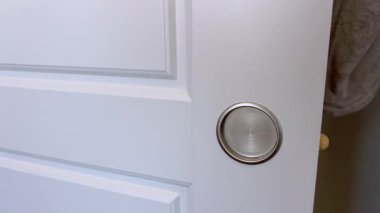 Hâlâ beyaz boyalı bir kapının çerçevesi var. Paneli açık ve çevresi çok az. Sahne, temiz bir koridorda hafifçe aydınlatılır..