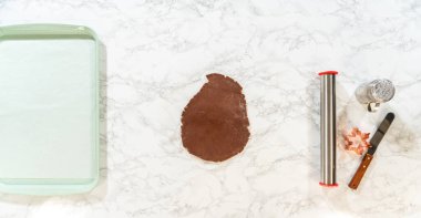 Çikolatalı kurabiye hamurunun küçük bir kısmını mermer bir yüzeye yerleştirip çikolatalı zencefilli kurabiye pişirmeye hazır hale getirmek..