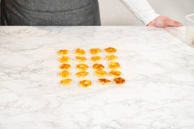 Limonlu kurabiyeler düzgünce yerleştirilmiş, yaban mersinli tereyağı kreması için hazır. Bu lezzetli ve canlı kurabiyeler ferahlatıcı bir limon aroması içeriyor, pürüzsüz ve keskin bir kızılcık ile eşleştirilmiş.