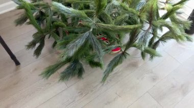 Yapay bir Noel ağacının tabanı iyi aydınlatılmış bir odanın penceresinin yanına kurulur. Toplama işlemi başlarken dallar yukarı doğru sıralanır..