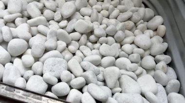 Metal bir pencerenin içindeki kayaları düzgünce düzenlenmiş beyaz peyzaj görüntüsü. Ev yapımı, gayrimenkul veya açık hava tasarım projelerinde kullanıma elverişli.