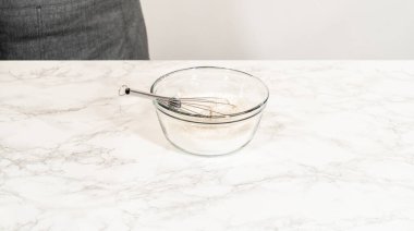 İçi kuru malzemelerle dolu cam bir kase. Limonlu kurabiye hamuru yapmak için gerekli bir adım bu..