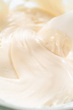 Pürüzsüz bir tutarlılık elde etmek için karıştırılan, kaymak gibi dokusunu yakından gören, Saf Beyaz Kraliyet Buzlu bir cam kase..