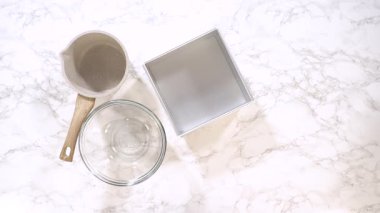 Eller beyaz mermer tezgahta un süzgeci, kase ve tavayı düzenler. Yemek hazırlama klipleri, yemek pişirme dersleri ve organizasyon sahneleri için harika..