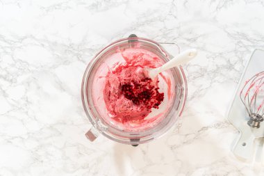 Limonlu kurabiyelerin yakın plan çekimi, kıvırcık yaban mersinli tereyağı kreması, canlı pembe dekorasyonlarını gösteriyor. Kurabiyeler düzgünce düzenlenmiş, sahneye renk ve doku katıyor.