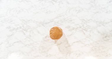 Amber Zencefilli Kurabiye Hamuru 'nun üst kısmı mermer bir yüzeye ayrılmış ve daha fazla şekil vermeye ya da soğutmaya hazırlanıyordu. Hamur esnek ve kurabiye ya da depolamaya hazır.