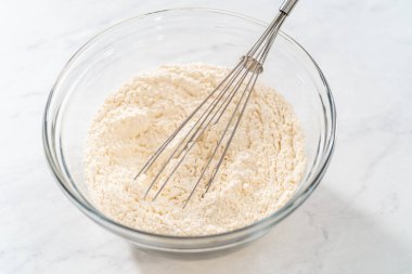 Kuru malzemelerle bardaktaki çırpıcıyı karıştırıp limonlu yaban mersinli kek yapıyorum..