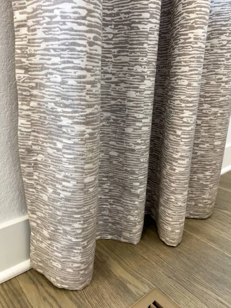 Zemin uzunluğunda gri perdeler, ince desenli perdeler, yumuşak ışıklandırılmış bir iç odada ahşap zemin ile buluşması için..