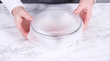 Beyaz mermer yüzeyinde şeker küpleri olan cam bir kasede tek bir taze çilek gösteren yakın çekim video klibi. Parlak ışıklandırma, temiz dokuları ve minimalist gıda tasarımını ön plana çıkarıyor..