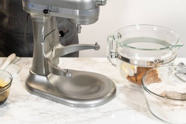 Cam bir kaseyle karıştırma işlemi sırasında baharatlı zencefilli kurabiye için mükemmel hamur işi karışımı. Esmer şeker ve tereyağı pürüzsüz bir hamur için bir araya getiriliyor..