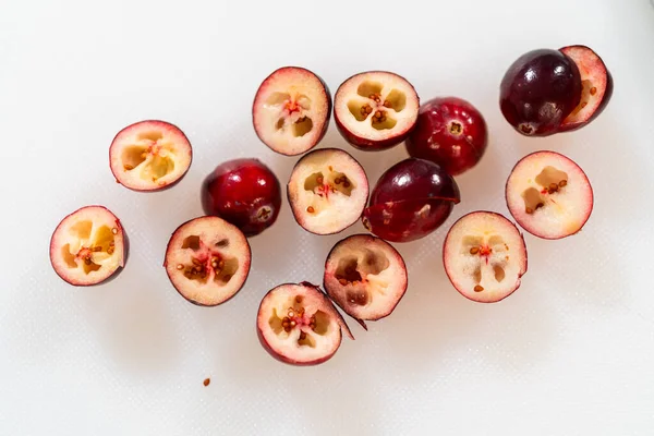 İkiye bölünmüş taze kızılcıklar, canlı kırmızı derileri, karmaşık iç kısımları ve küçük tohumları sergiliyor. Sulu doku ve doğal detaylar bu resmi resmetmek için ideal hale getiriyor.